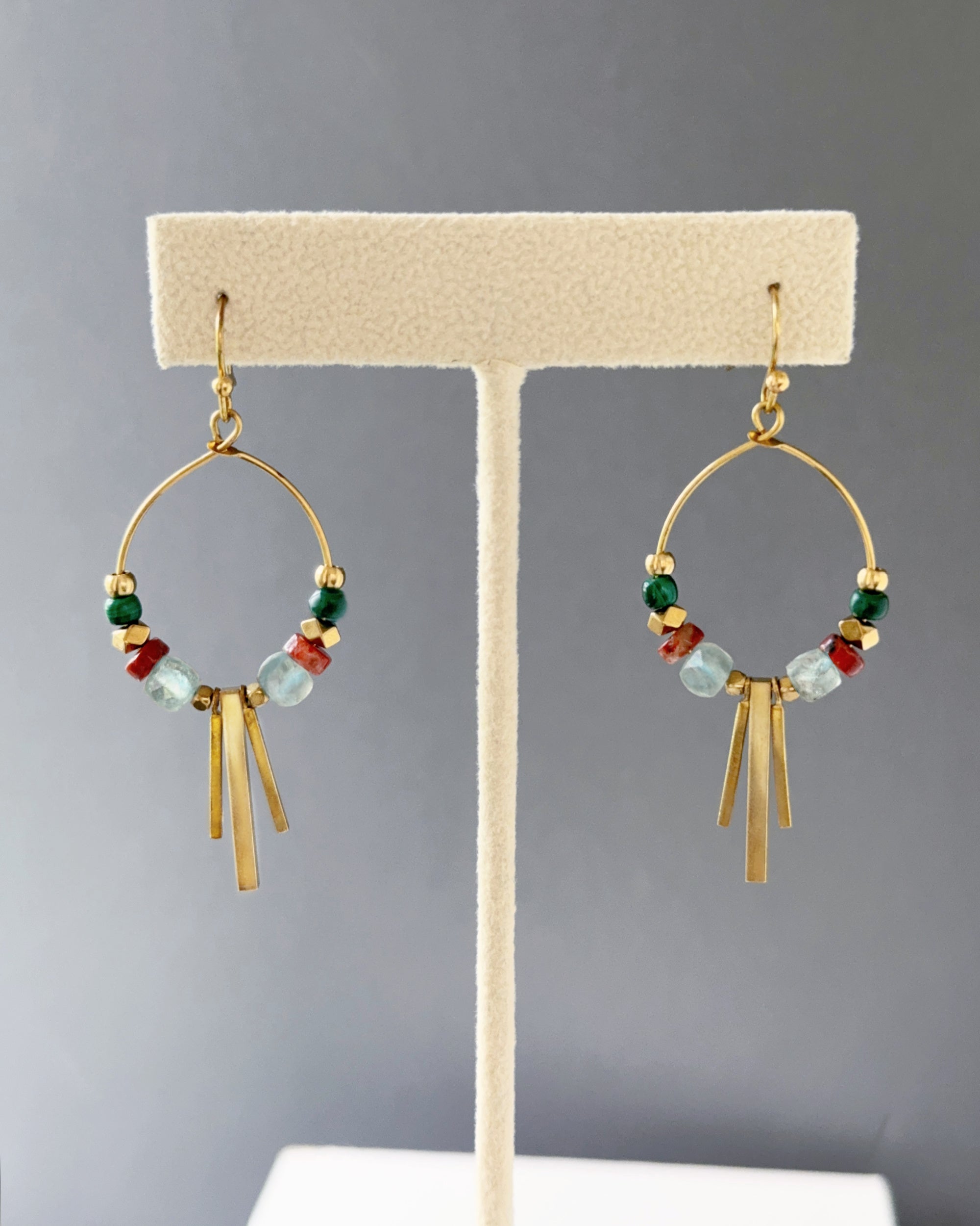 Brass hoop earrings with green malachite, sesame jasper and aqua apatite stones, and edgy brass fringe on an earring stand — Soren apatite hoop by Alysian.