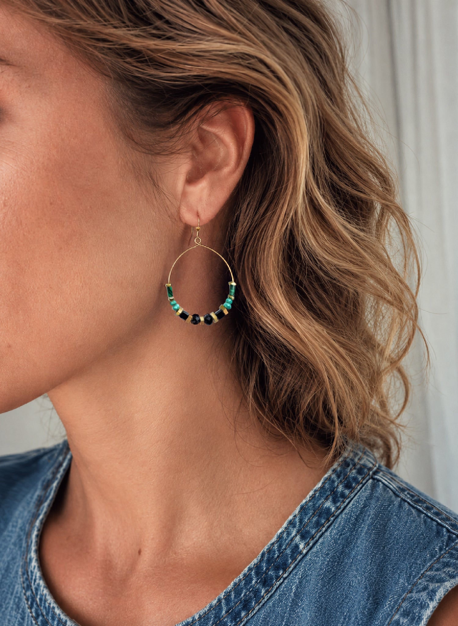 Close-up of a woman wearing the Adira Gemstone Hoop Earrings, handcrafted by Alysian.
