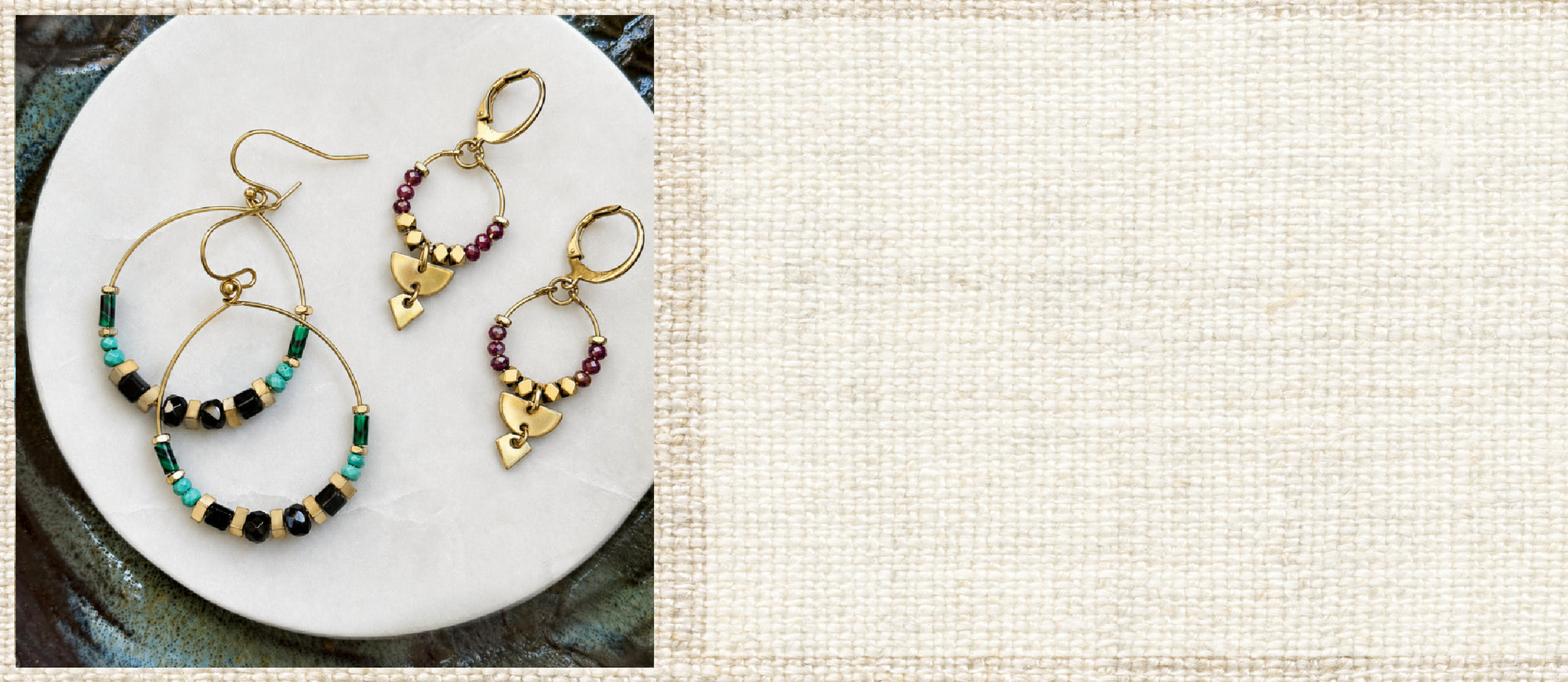 Two pairs of handcrafted gold brass hoop and dangle earrings with gemstones, displayed on a ceramic plate against a textured beige linen background.