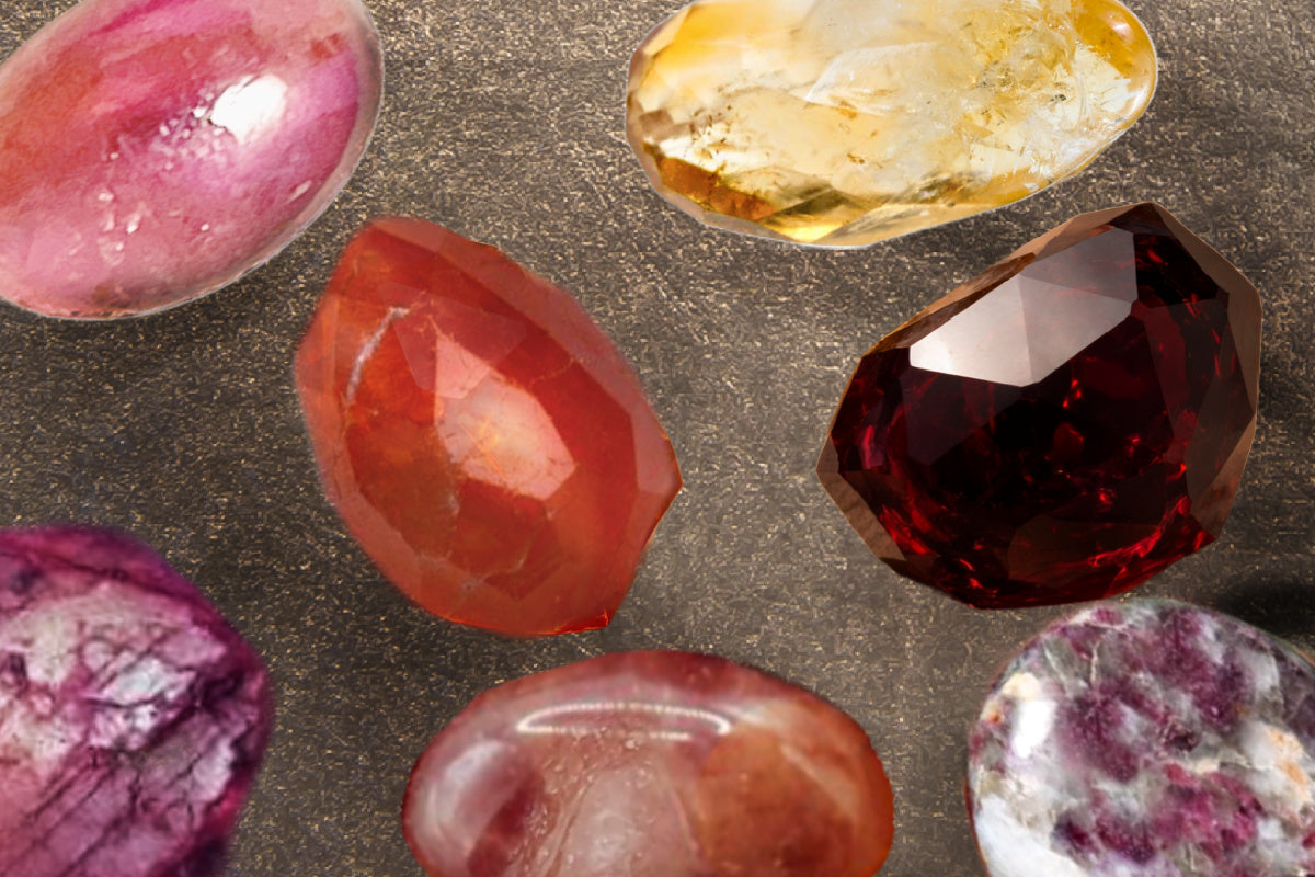 An arrangement of gemstones in warm color tones, including carnelian, ruby, pink tourmaline, citrine, garnet and red aventurine. 