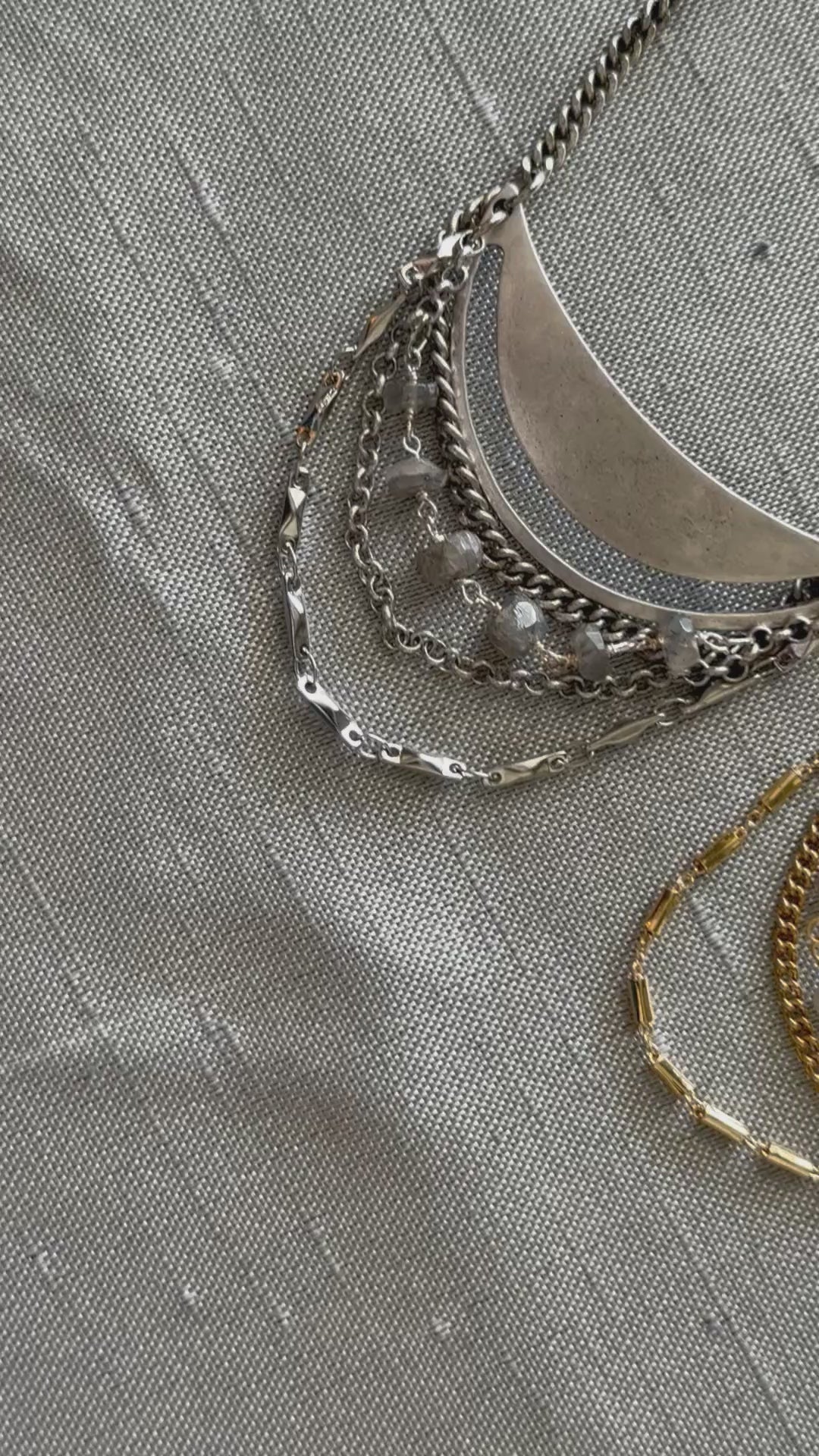 Silver-tone Lusine adjustable crescent pendant necklace with draped chains and gemstones, close up, handcrafted by Alysian.