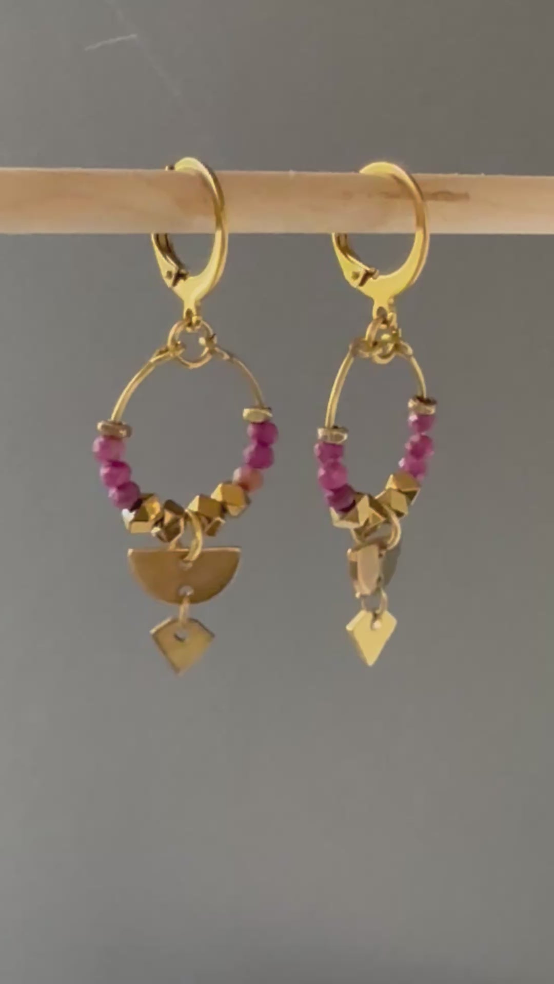 A video of Alysian Islene Ruby Mini Hoop Earrings close up with gemstones and brass accents shimmering.