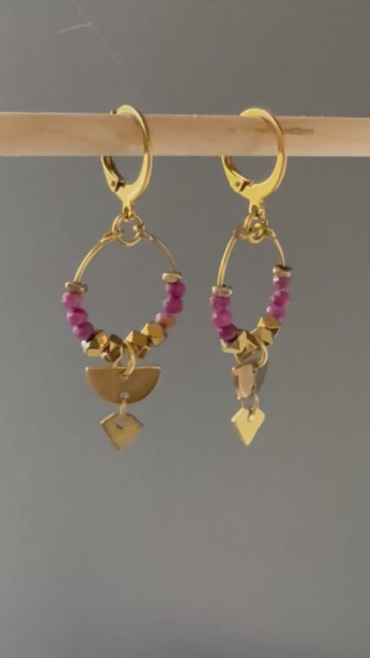 A video of Alysian Islene Ruby Mini Hoop Earrings close up with gemstones and brass accents shimmering.